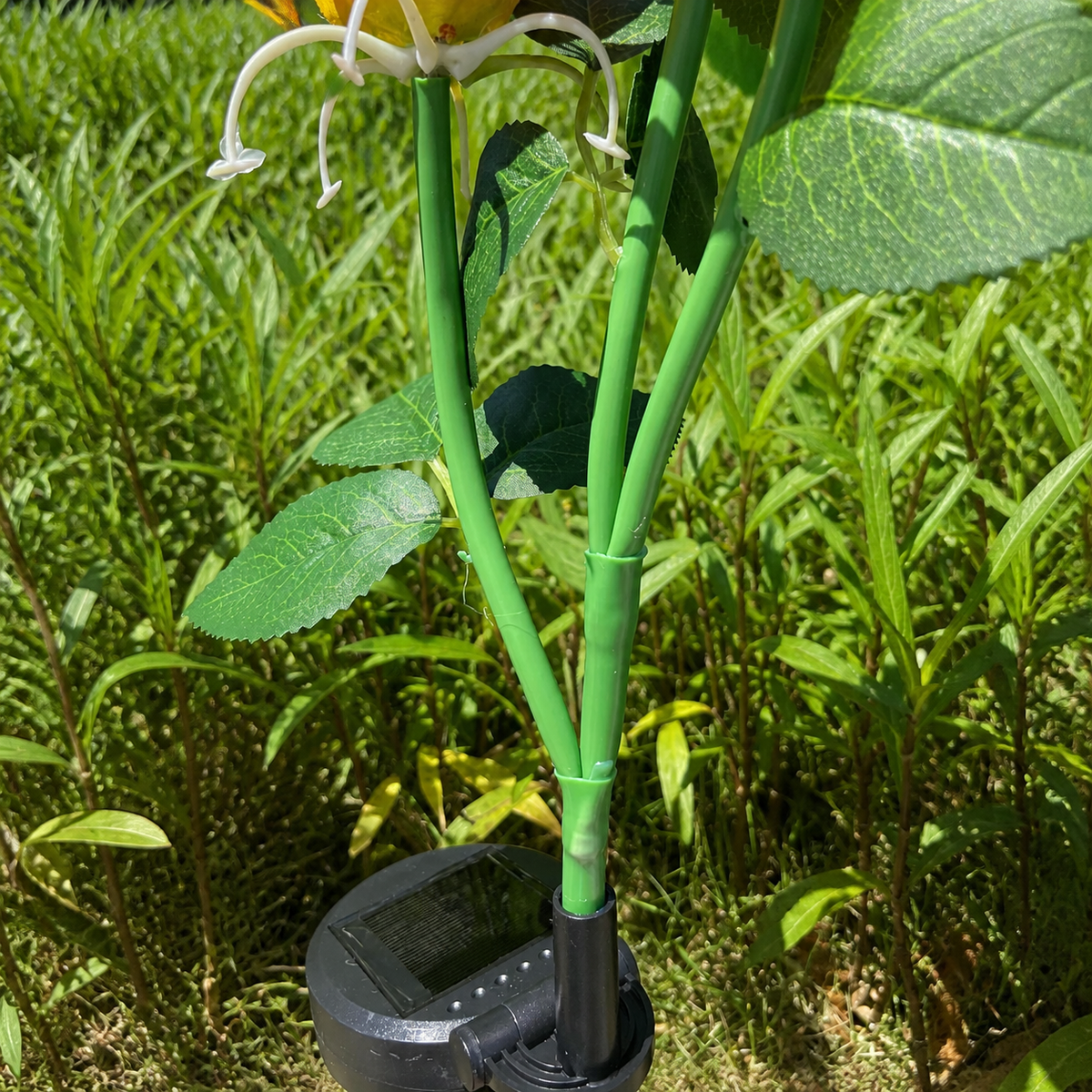 Close-up of the green stem connector on a solar fire lily garden light