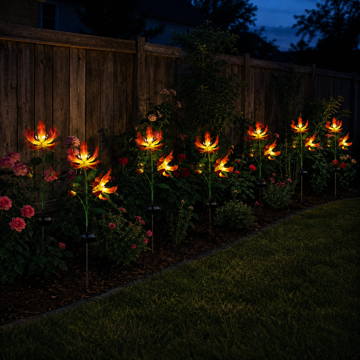 Solar fire lily lights continuing along a fence line after dark