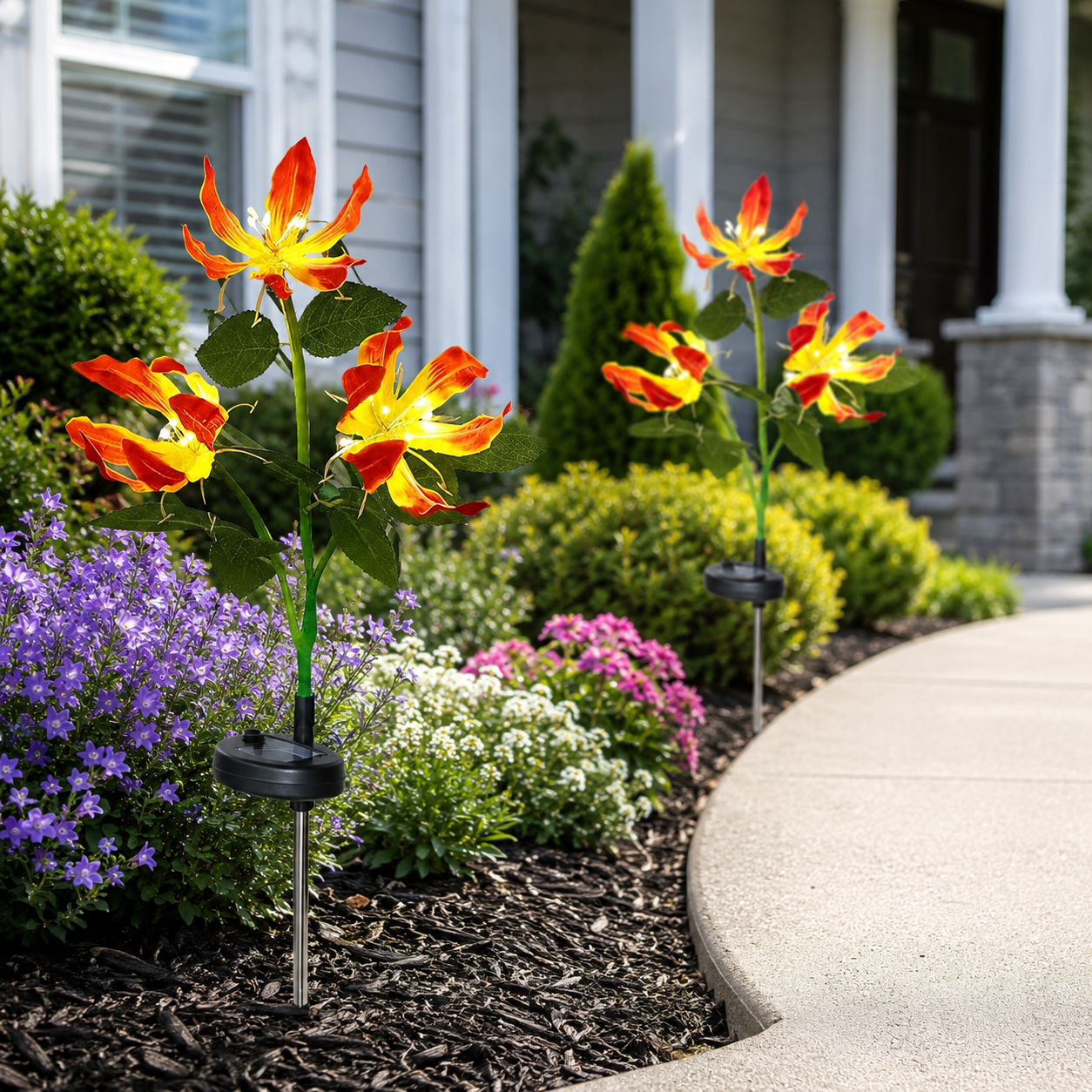 Solar flame lily stake lights placed in a flower bed during the day