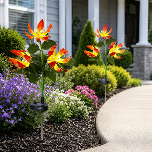Solar flame lily stake lights placed in a flower bed during the day